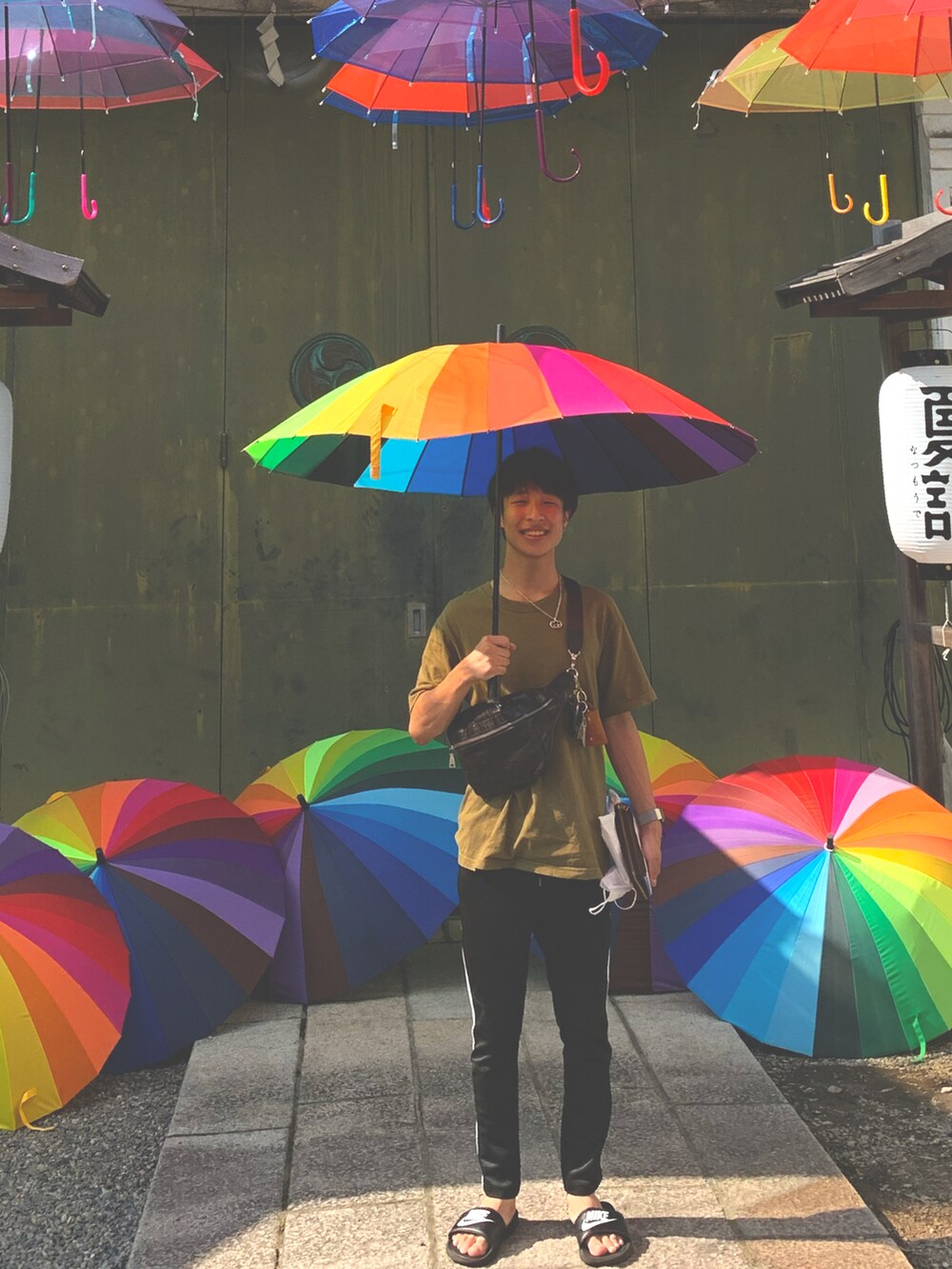 ブラック系のその他パンツ、ブラック系のサンダル、その他のキーホルダーを着用したメンズの夏コーディネートの2枚目の写真