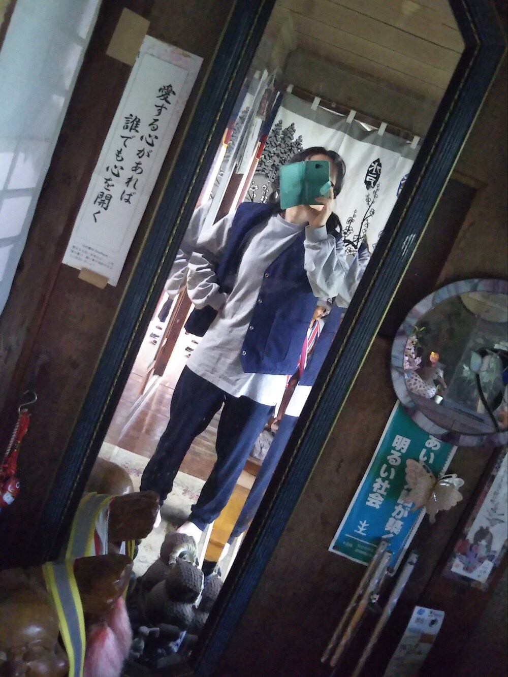 グレー系のスウェット、ブルー系のベスト、ブラック系のスウェットパンツを着用したレディースの秋コーディネートの2枚目の写真