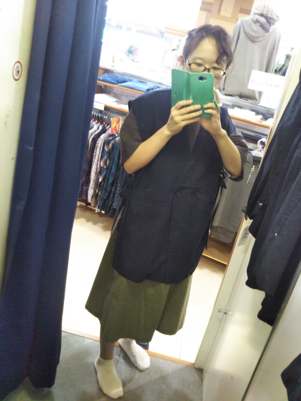 グレー系のTシャツ/カットソー、ホワイト系のシャツ/ブラウス、ブルー系のベストを着用したレディースの秋コーディネートの2枚目の写真