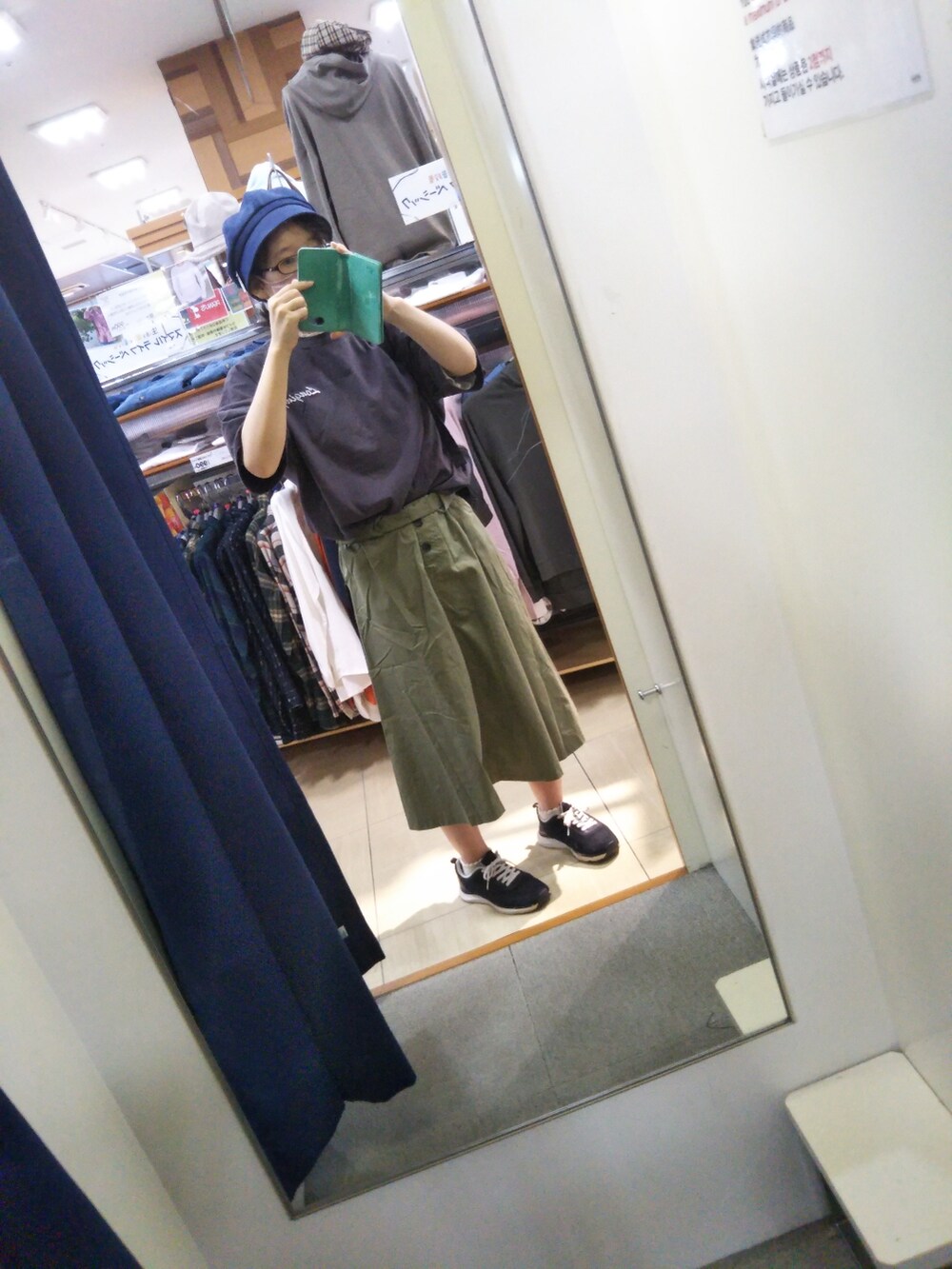 グレー系のTシャツ/カットソー、グリーン系のスカート、ブルー系のキャスケットを着用したレディースの秋コーディネートの2枚目の写真