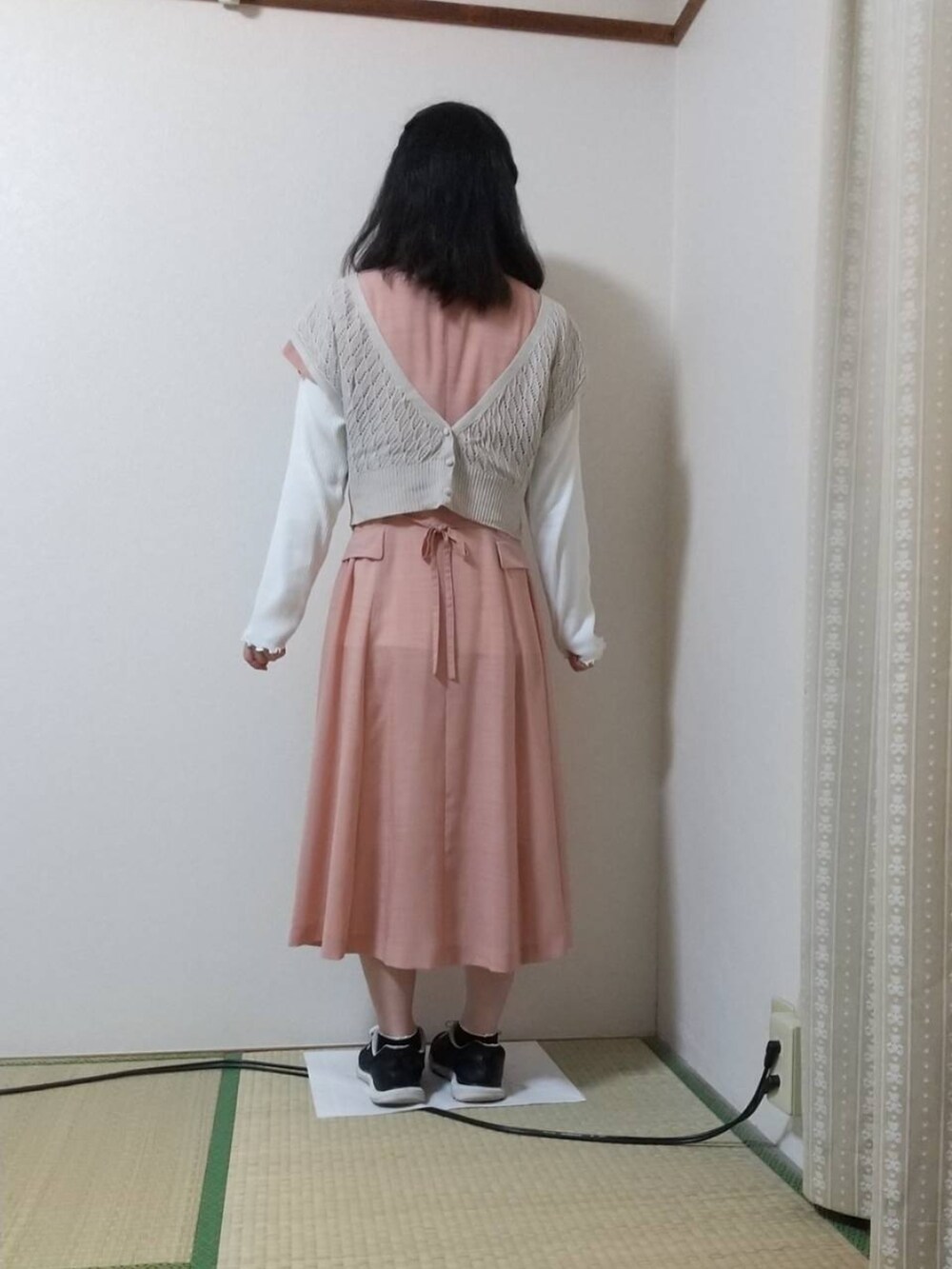 ホワイト系のTシャツ/カットソー、ベージュ系のベスト、ピンク系のワンピースを着用したレディースの秋コーディネートの2枚目の写真