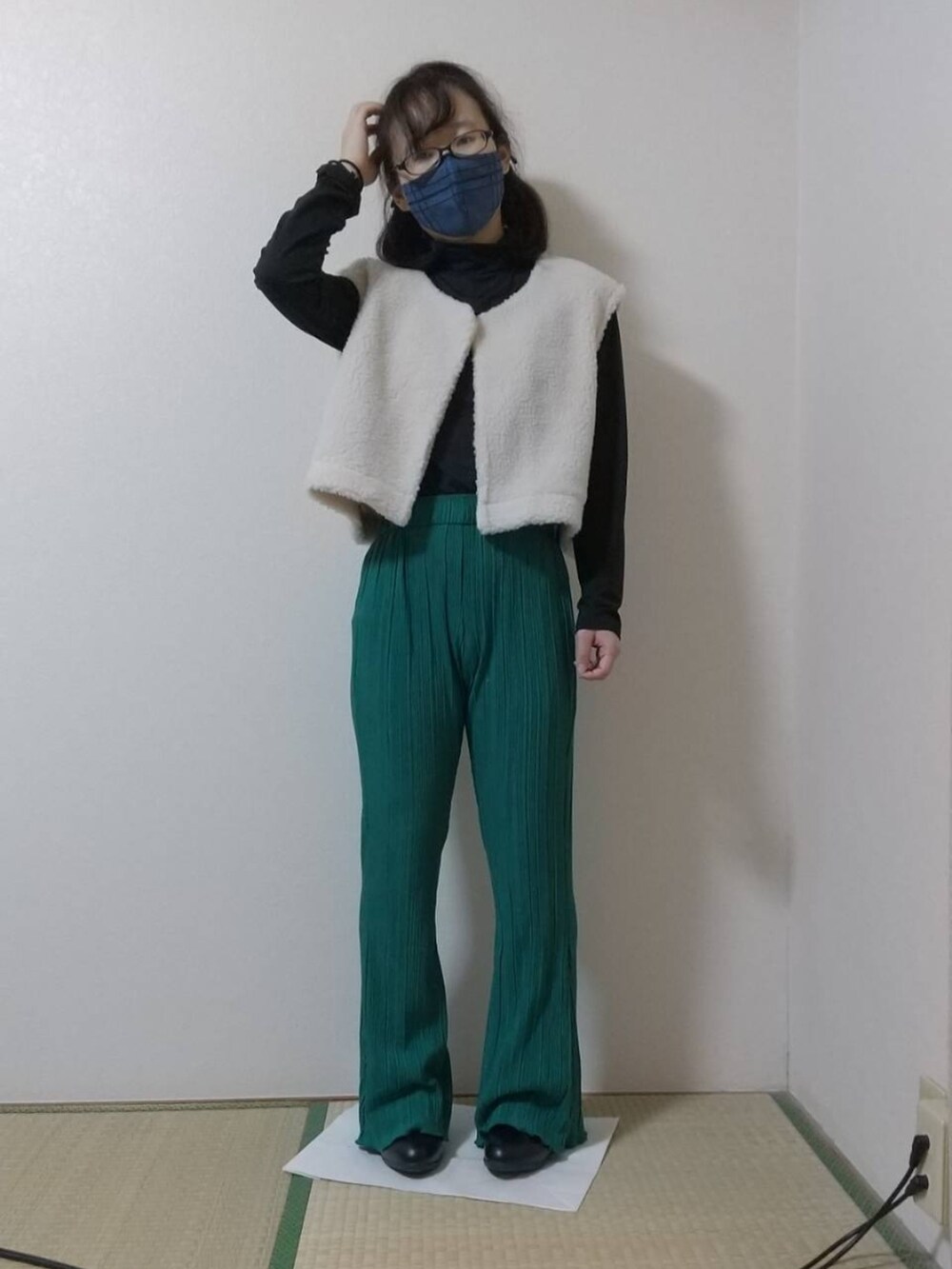 ブラック系のその他トップス、ホワイト系のベスト、グリーン系のその他パンツを着用したレディースの秋コーディネートの3枚目の写真