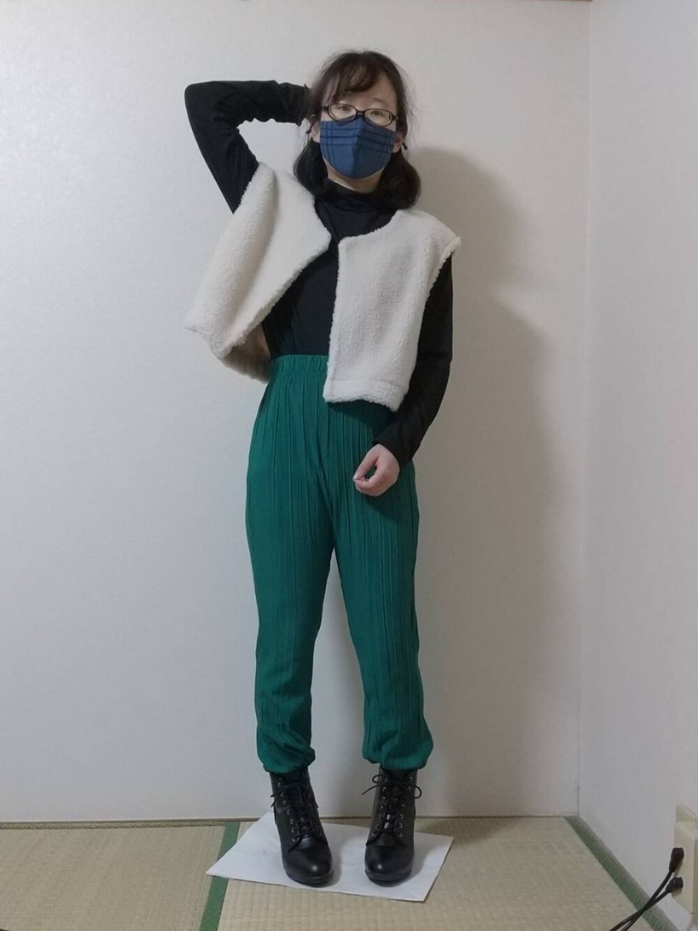 ブラック系のその他トップス、ホワイト系のベスト、グリーン系のその他パンツを着用したレディースの秋コーディネートの2枚目の写真