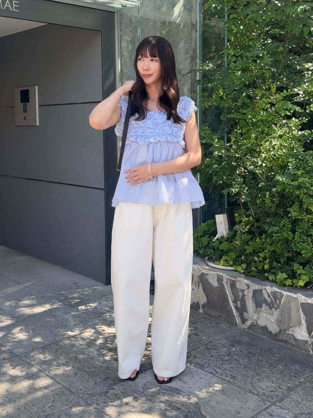 ブルー系のシャツ/ブラウス、ホワイト系のデニムパンツを着用したレディースの春コーディネートの2枚目の写真