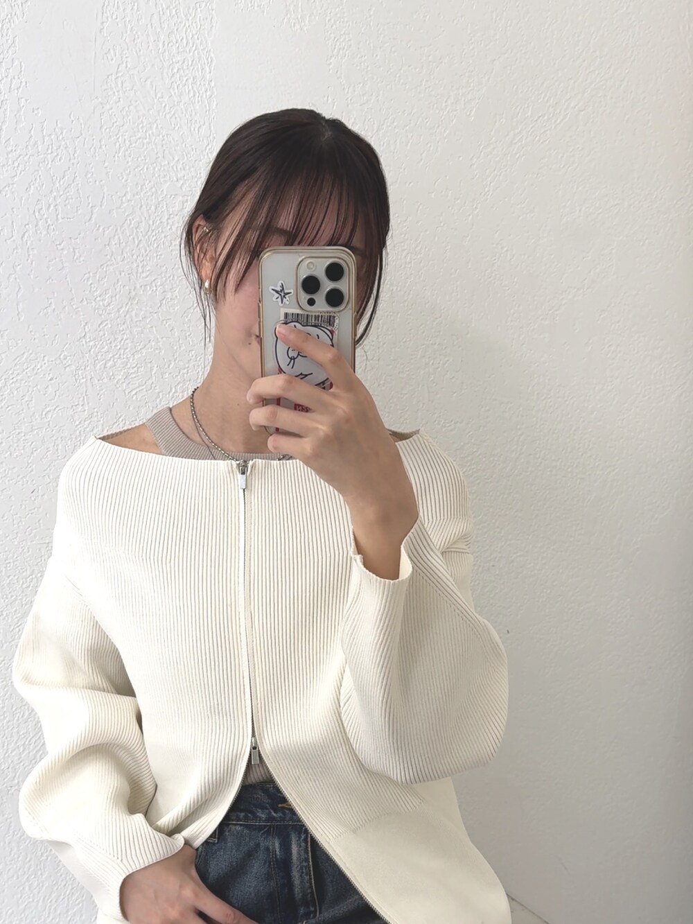 ホワイト系のカーディガン/ボレロ、ブルー系のデニムパンツ、ブラック系のローファーを着用したレディースの秋コーディネートの4枚目の写真