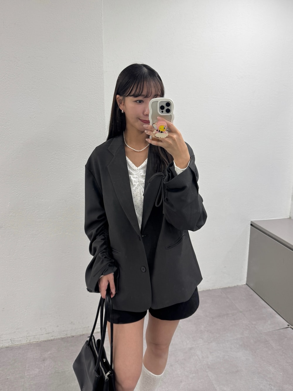 グレー系のテーラードジャケット、ブラック系のその他パンツ、ブラック系のパンプスを着用したレディースの冬コーディネートの2枚目の写真