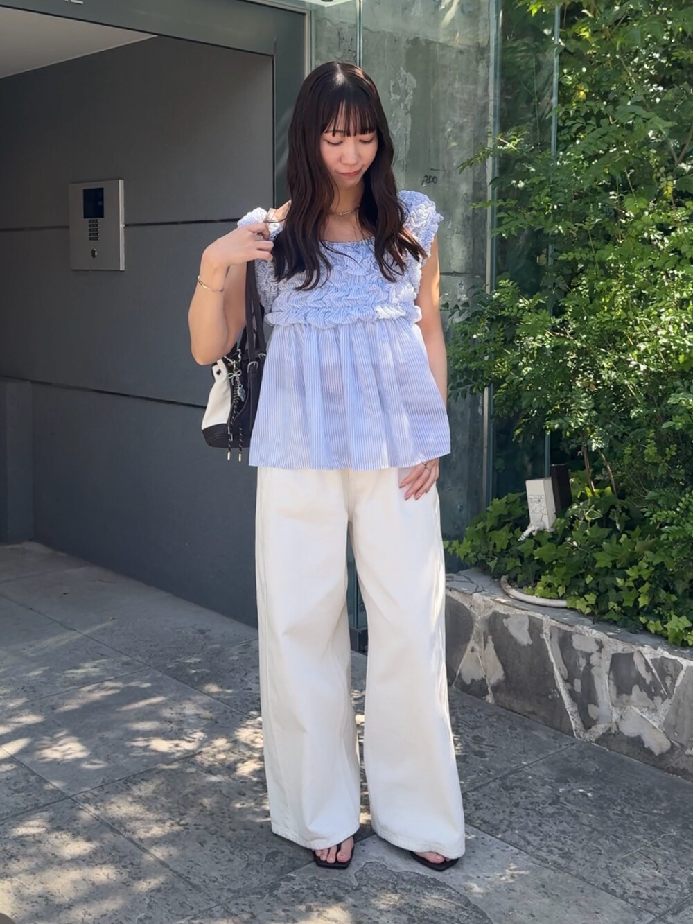 ブルー系のシャツ/ブラウス、ホワイト系のデニムパンツを着用したレディースの春コーディネートの3枚目の写真