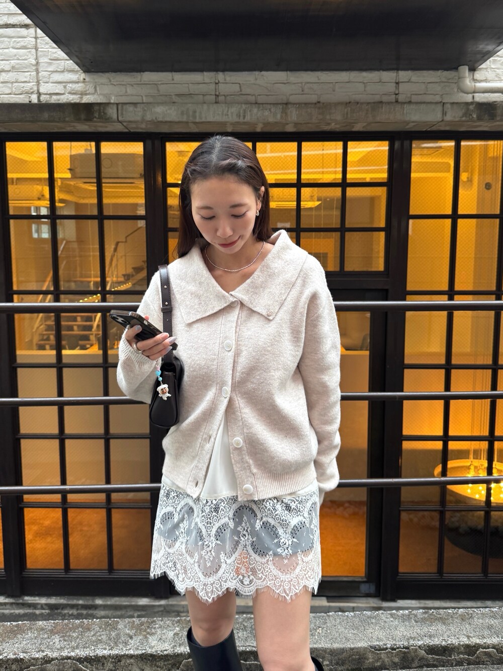 ホワイト系のカーディガン/ボレロ、ブラック系のその他パンツ、ブラック系のブーツを着用したレディースの秋コーディネートの3枚目の写真