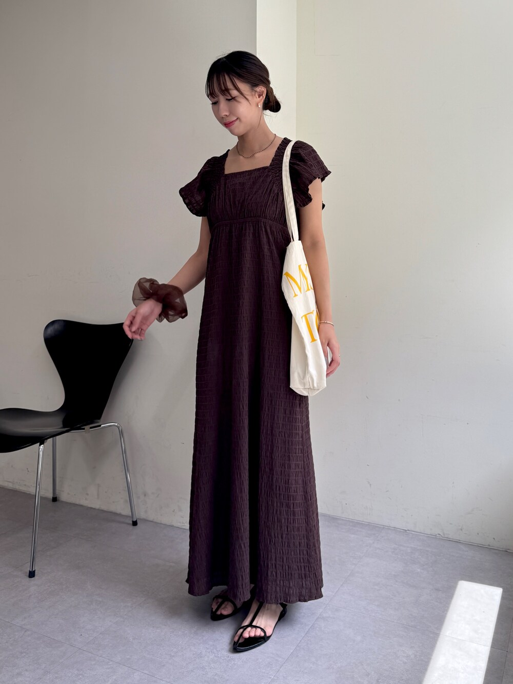 ブラウン系のワンピース、ホワイト系のトートバッグを着用したレディースの夏コーディネートの2枚目の写真