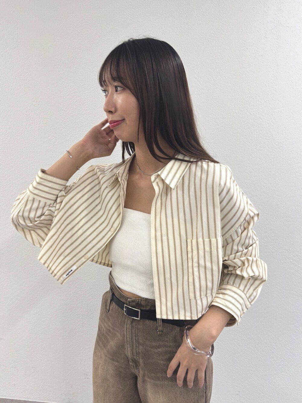 ホワイト系のシャツ/ブラウス、ブラウン系のデニムパンツを着用したレディースの夏コーディネートの2枚目の写真