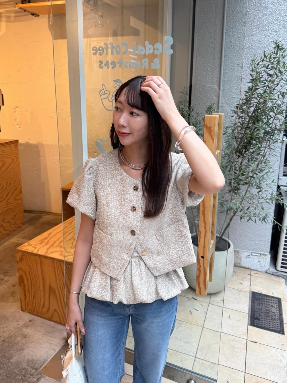 ベージュ系のシャツ/ブラウス、ブルー系のデニムパンツ、シルバー系のサンダルを着用したレディースの夏コーディネートの2枚目の写真