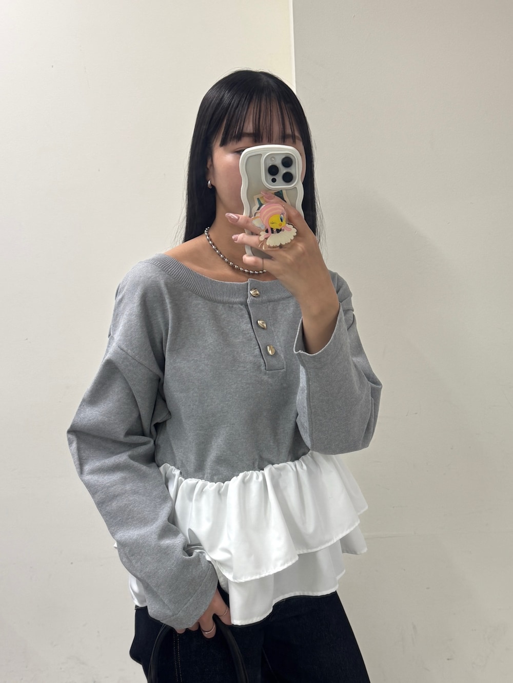 グレー系のニット/セーター、ブルー系のデニムパンツ、ブラック系のパンプスを着用したレディースの冬コーディネートの2枚目の写真