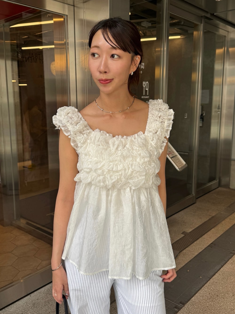 ホワイト系のシャツ/ブラウス、ホワイト系のその他パンツ、ブラック系のトートバッグを着用したレディースの春コーディネートの3枚目の写真