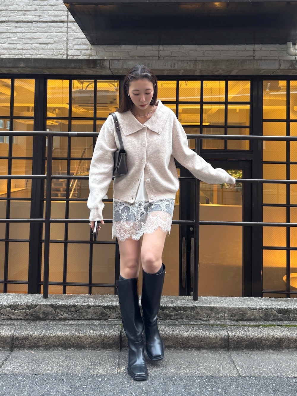 ホワイト系のカーディガン/ボレロ、ブラック系のその他パンツ、ブラック系のブーツを着用したレディースの秋コーディネートの2枚目の写真