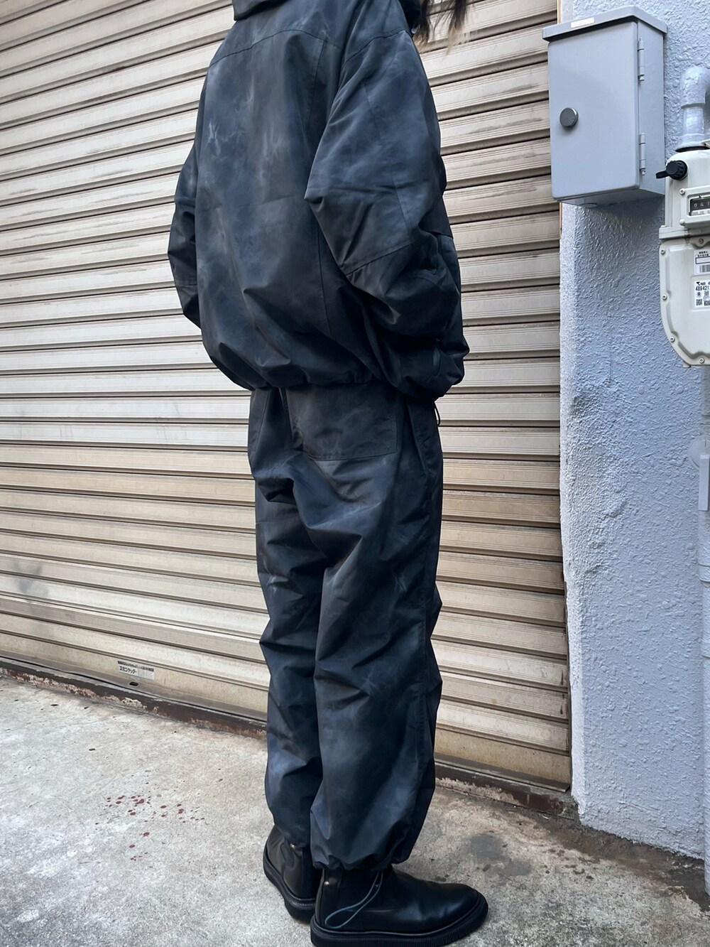 ブラック系のブーツ、ブラック系のマウンテンパーカー、ブラック系のカーゴパンツを着用したメンズの秋コーディネートの3枚目の写真