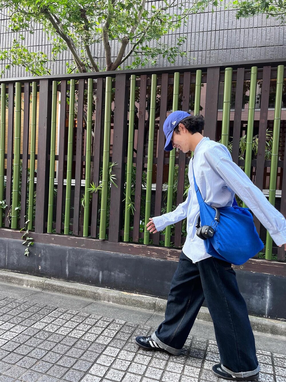 ブラック系のスニーカー、ブルー系のデニムパンツ、ブルー系のキャップを着用したメンズの秋コーディネートの3枚目の写真