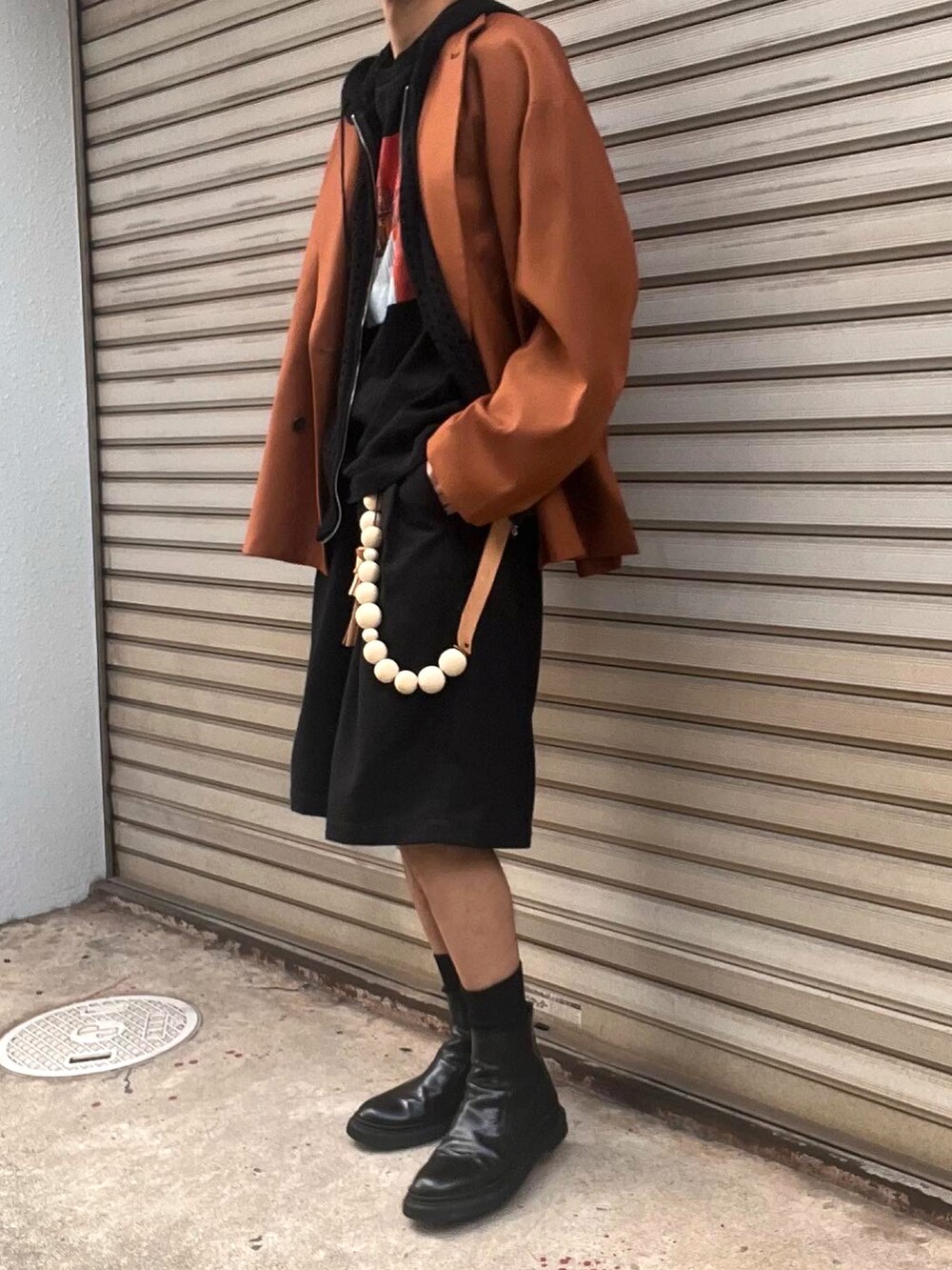 その他のTシャツ/カットソー、オレンジ系のテーラードジャケット、ブラック系のその他パンツを着用したメンズの秋コーディネートの4枚目の写真