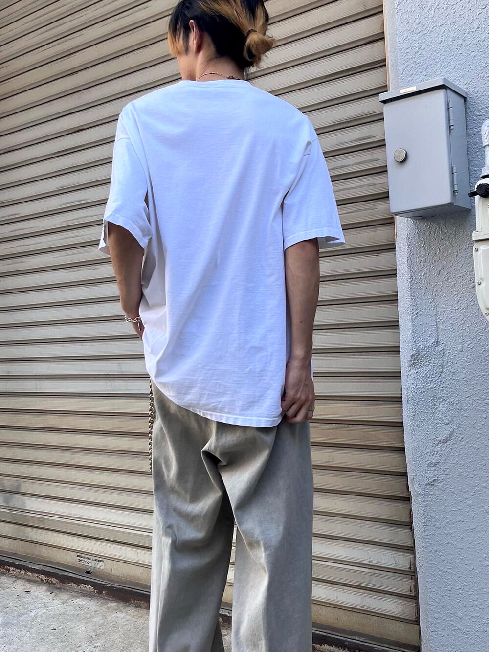 グレー系のデニムパンツ、ブラック系のスニーカーを着用したメンズの秋コーディネートの4枚目の写真