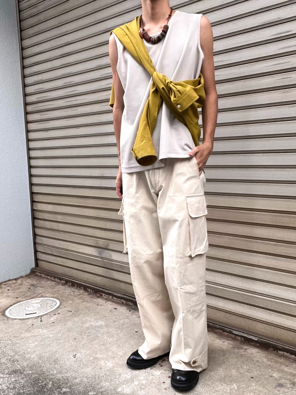 ブラック系のブーツ、ホワイト系のカーゴパンツ、イエロー系のシャツ/ブラウスを着用したメンズの秋コーディネートの3枚目の写真