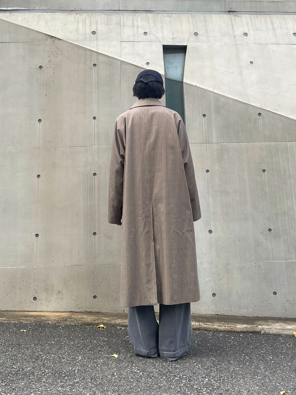 グレー系のデニムパンツ、シルバー系のスニーカー、オレンジ系のトップスを着用したメンズの秋コーディネートの3枚目の写真