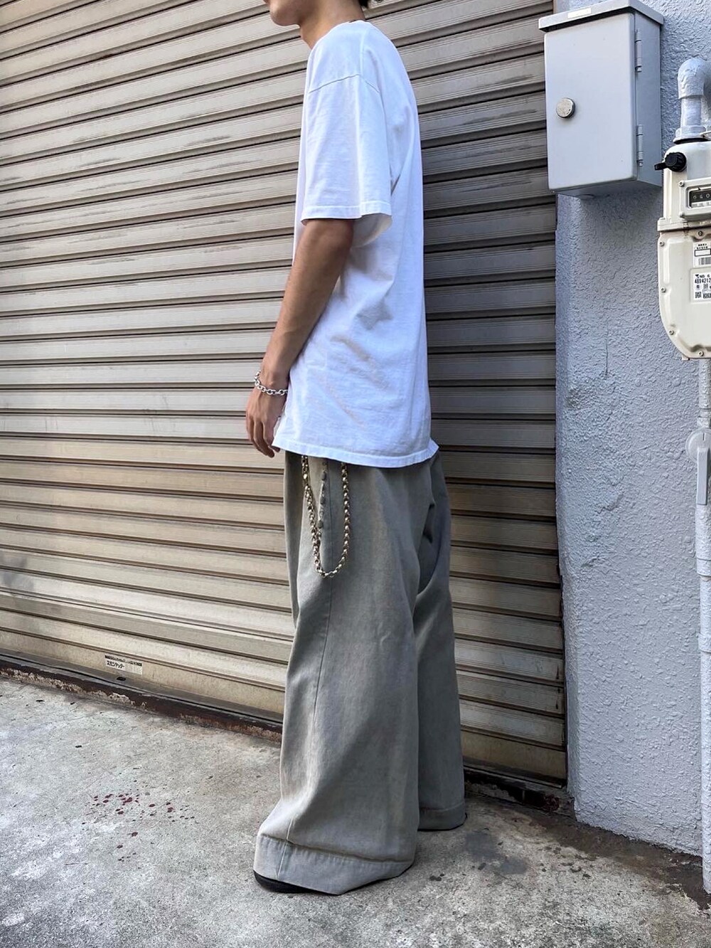 グレー系のデニムパンツ、ブラック系のスニーカーを着用したメンズの秋コーディネートの2枚目の写真