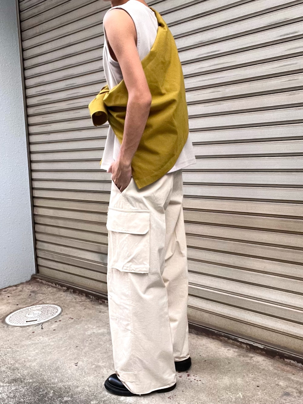 ブラック系のブーツ、ホワイト系のカーゴパンツ、イエロー系のシャツ/ブラウスを着用したメンズの秋コーディネートの4枚目の写真