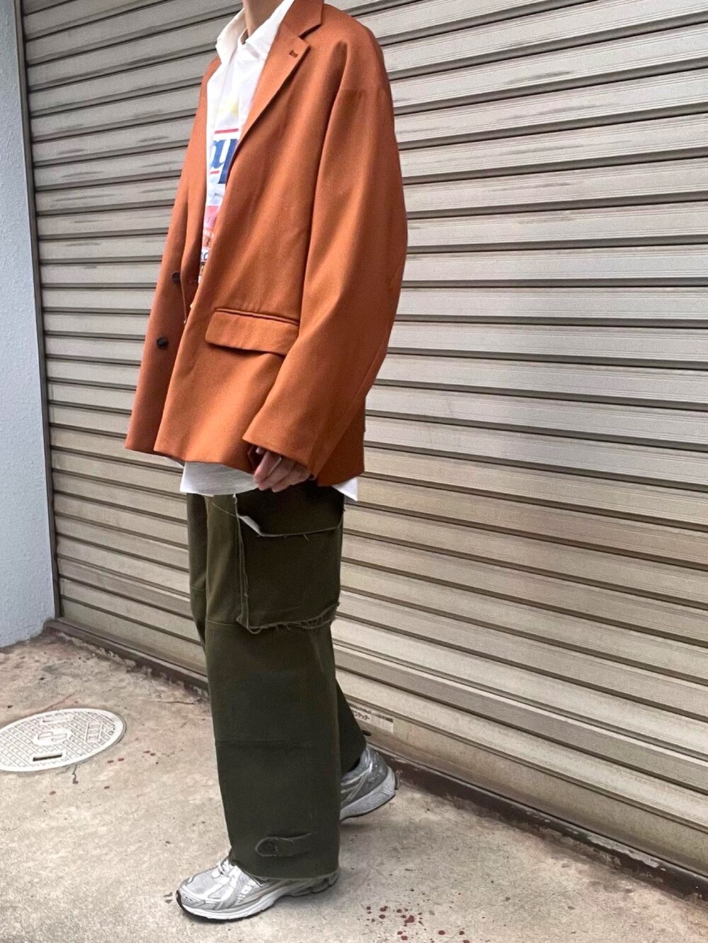 グリーン系のカーゴパンツ、シルバー系のスニーカー、オレンジ系のテーラードジャケットを着用したメンズの秋コーディネートの3枚目の写真