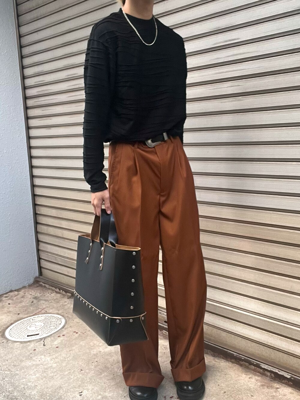 ブラック系のブーツ、オレンジ系のスラックス、オレンジ系のテーラードジャケットを着用したメンズの秋コーディネートの3枚目の写真