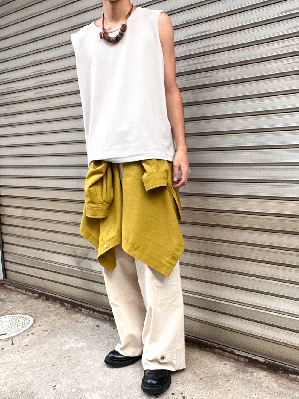 ブラック系のブーツ、ホワイト系のカーゴパンツ、イエロー系のシャツ/ブラウスを着用したメンズの秋コーディネートの5枚目の写真