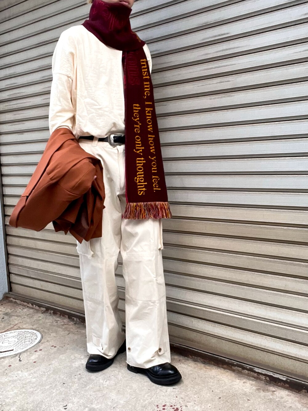 ブラック系のブーツ、ホワイト系のカーゴパンツ、オレンジ系のテーラードジャケットを着用したメンズの秋コーディネートの2枚目の写真