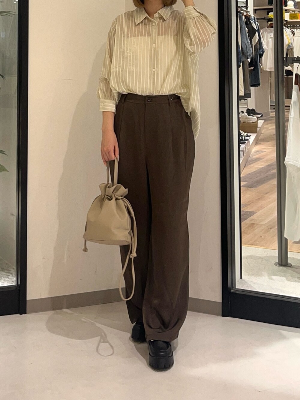 ホワイト系のシャツ/ブラウス、ブラウン系のパンツ、ブラウン系のショルダーバッグを着用したレディースの夏コーディネートの3枚目の写真