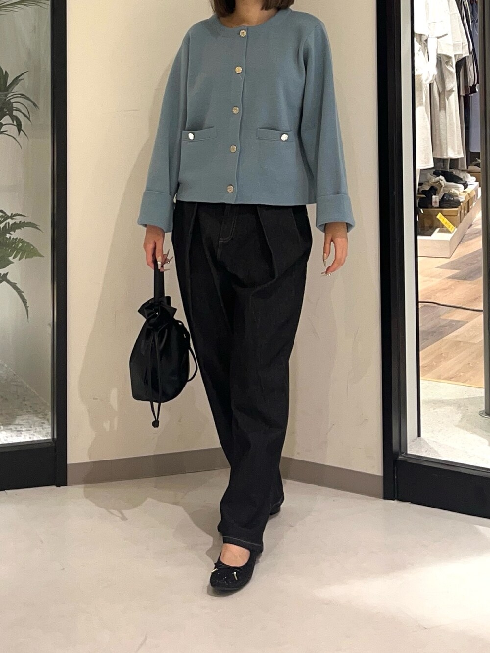 ブラック系のショルダーバッグ、ブラック系のデニムパンツ、ブラック系のブーツを着用したレディースの秋コーディネートの3枚目の写真