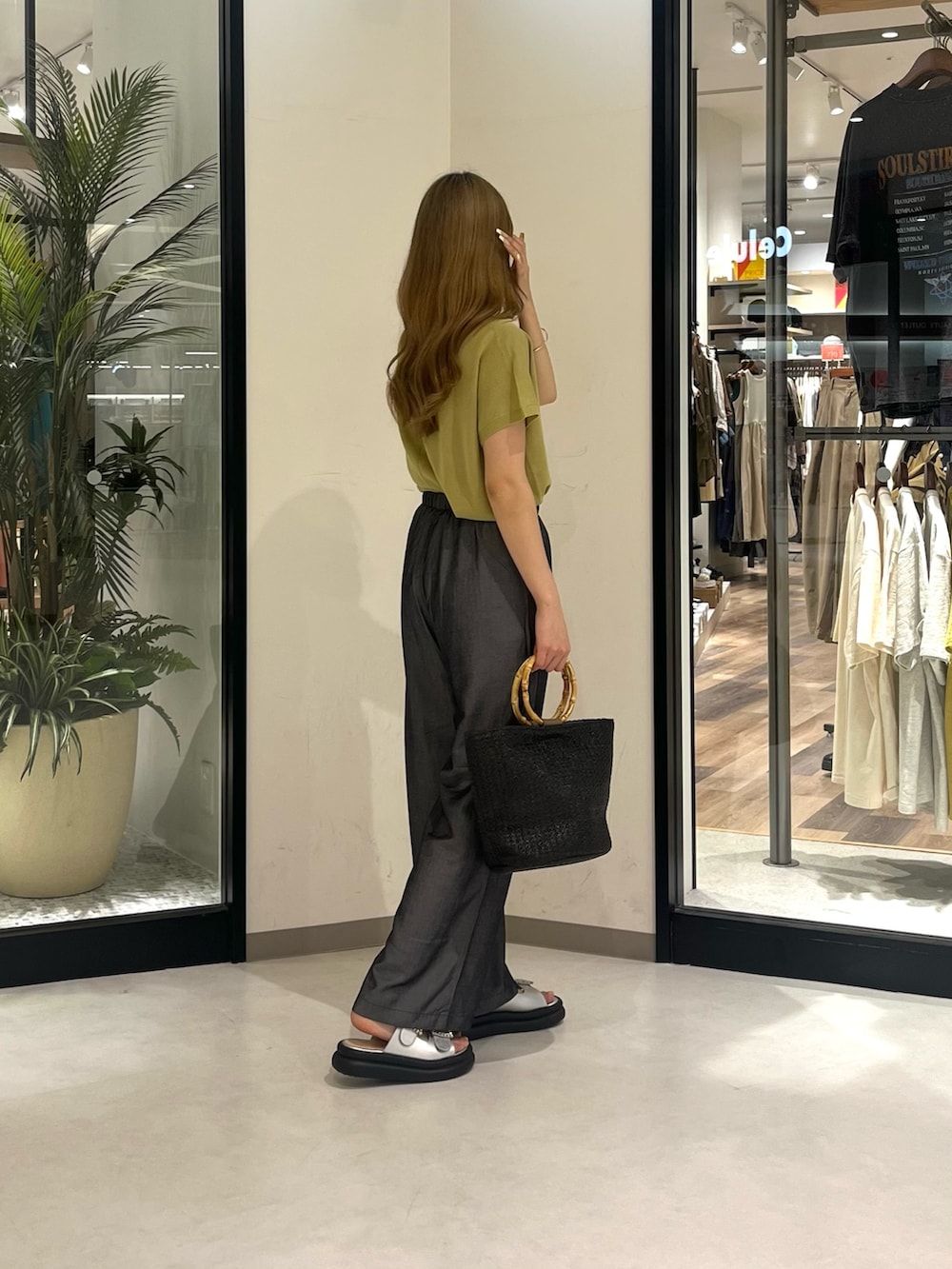 シルバー系のシューズ、ブラック系のパンツ、ブラック系のバッグを着用したレディースの夏コーディネートの2枚目の写真