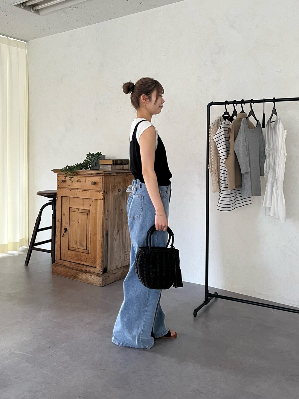 ブラック系のサンダル、ブルー系のデニムパンツ、ブラック系のバッグを着用したレディースの夏コーディネートの3枚目の写真