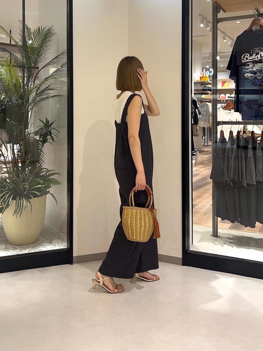 ホワイト系のニット/セーター、ベージュ系のバッグ、ゴールド系のシューズを着用したレディースの夏コーディネートの2枚目の写真