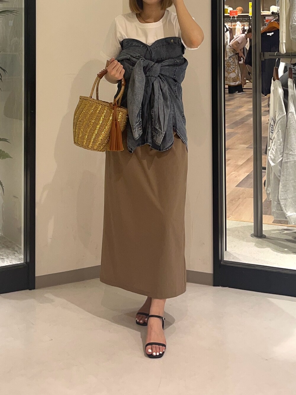 ホワイト系のTシャツ/カットソー、ブラック系のシューズ、ベージュ系のスカートを着用したレディースの夏コーディネートの3枚目の写真