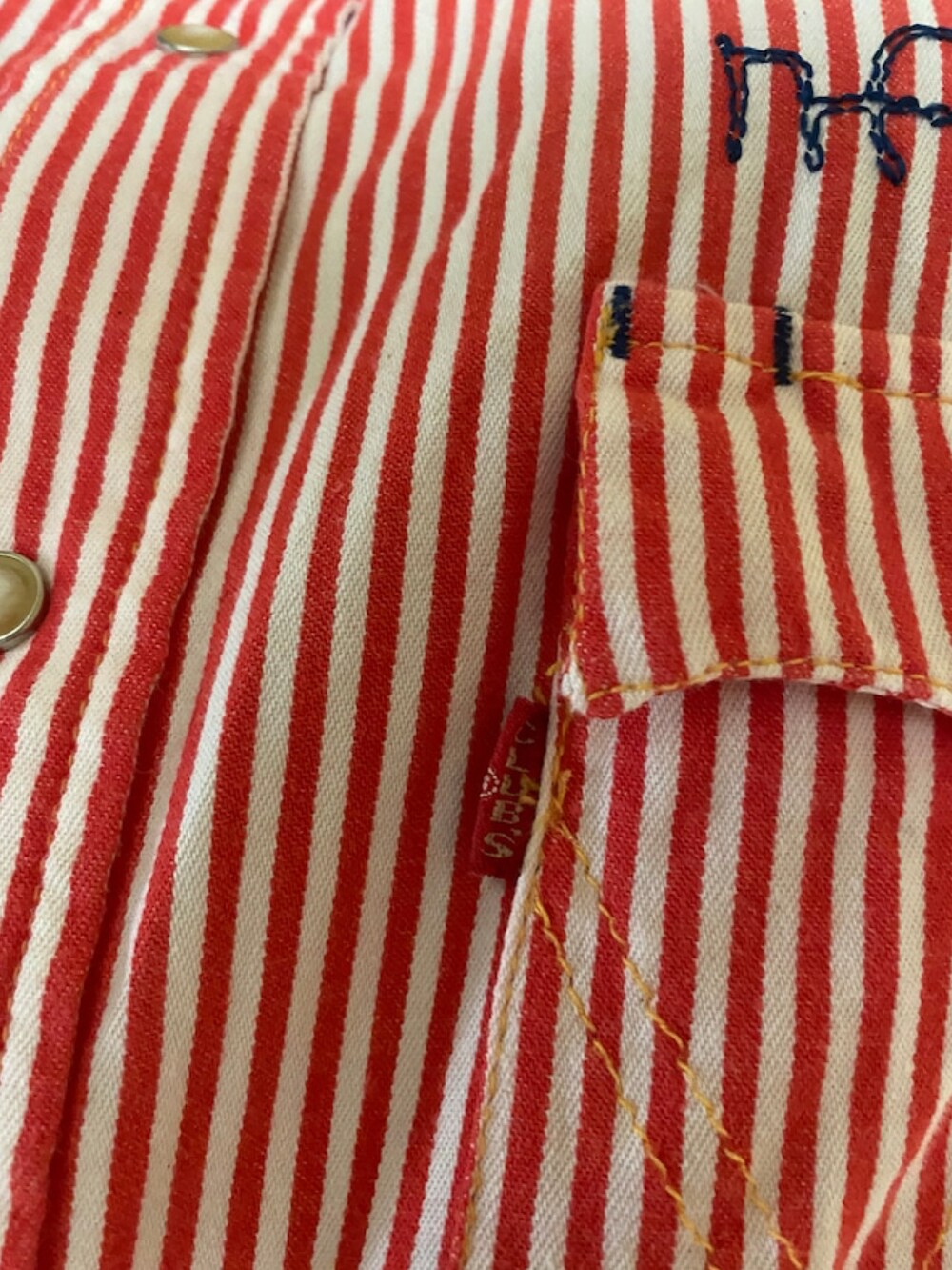 レッド系のミリタリージャケットを着用したレディースの夏コーディネートの2枚目の写真