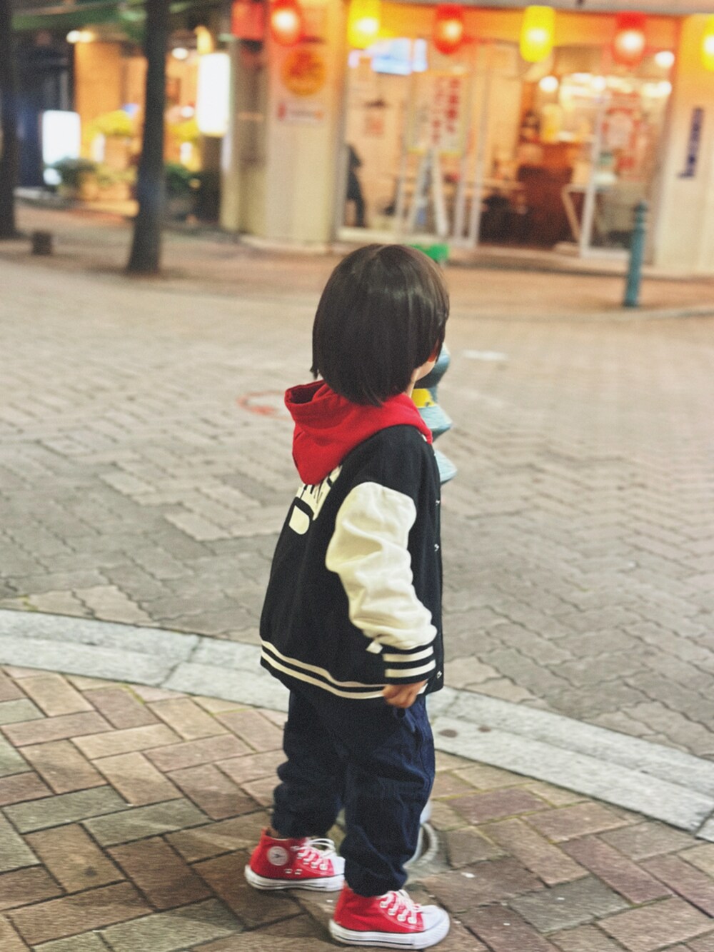 レッド系のパーカー、ブラック系のデニムジャケットを着用したキッズの秋コーディネートの2枚目の写真