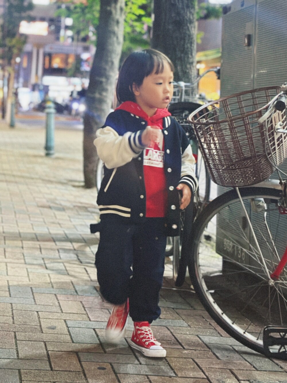 レッド系のパーカー、ブラック系のデニムジャケットを着用したキッズの秋コーディネートの3枚目の写真