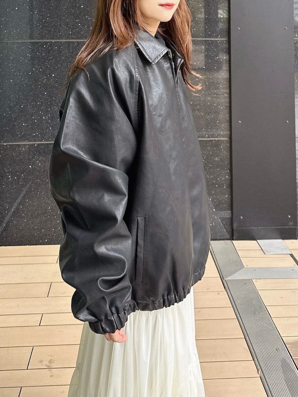 ブラック系のブルゾン、ブラック系のショルダーバッグ、ブラック系のブーツを着用したレディースの冬コーディネートの4枚目の写真