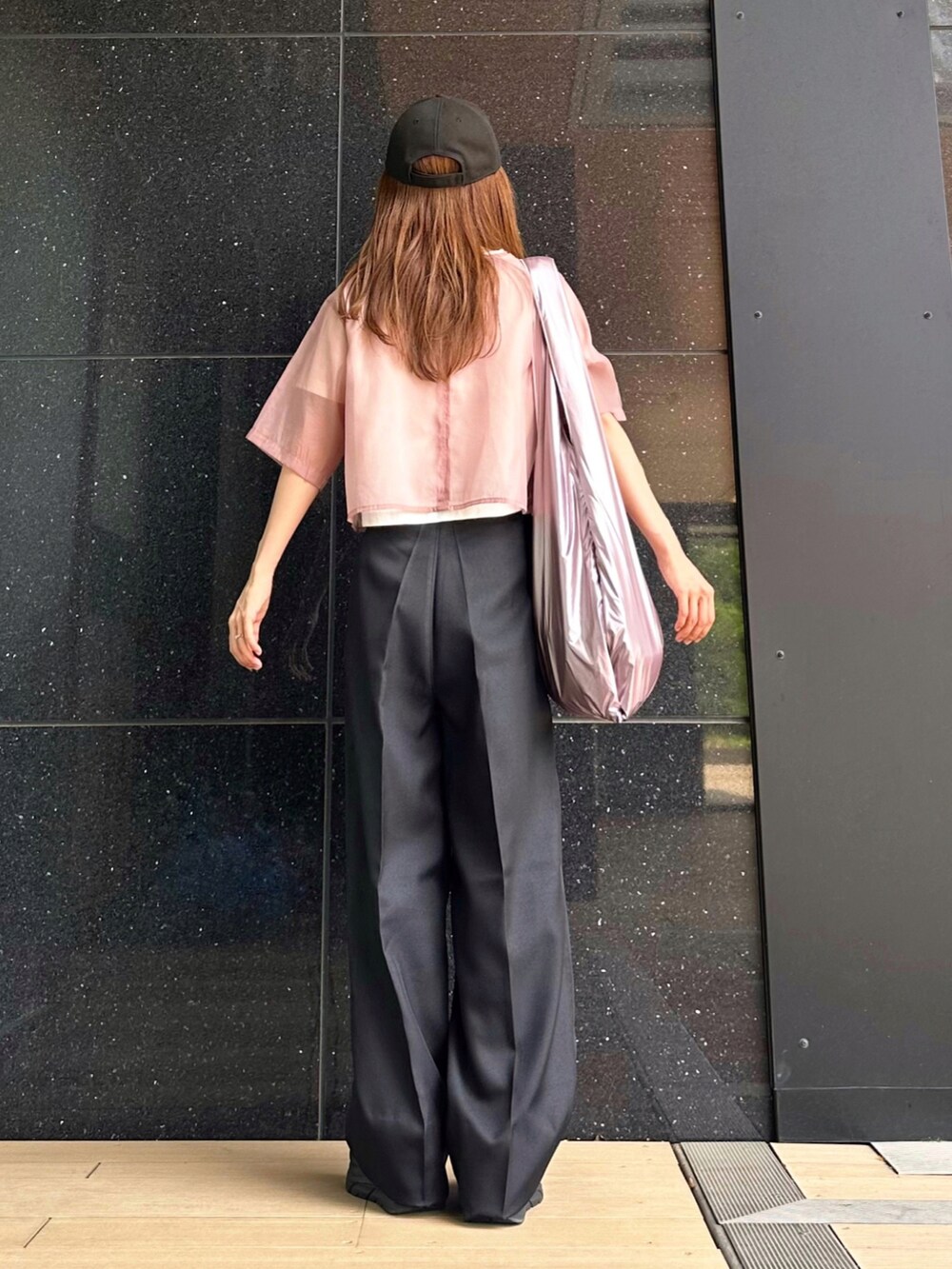 ブラック系のスラックス、ピンク系のシャツ/ブラウス、ホワイト系のTシャツ/カットソーを着用したレディースの夏コーディネートの2枚目の写真