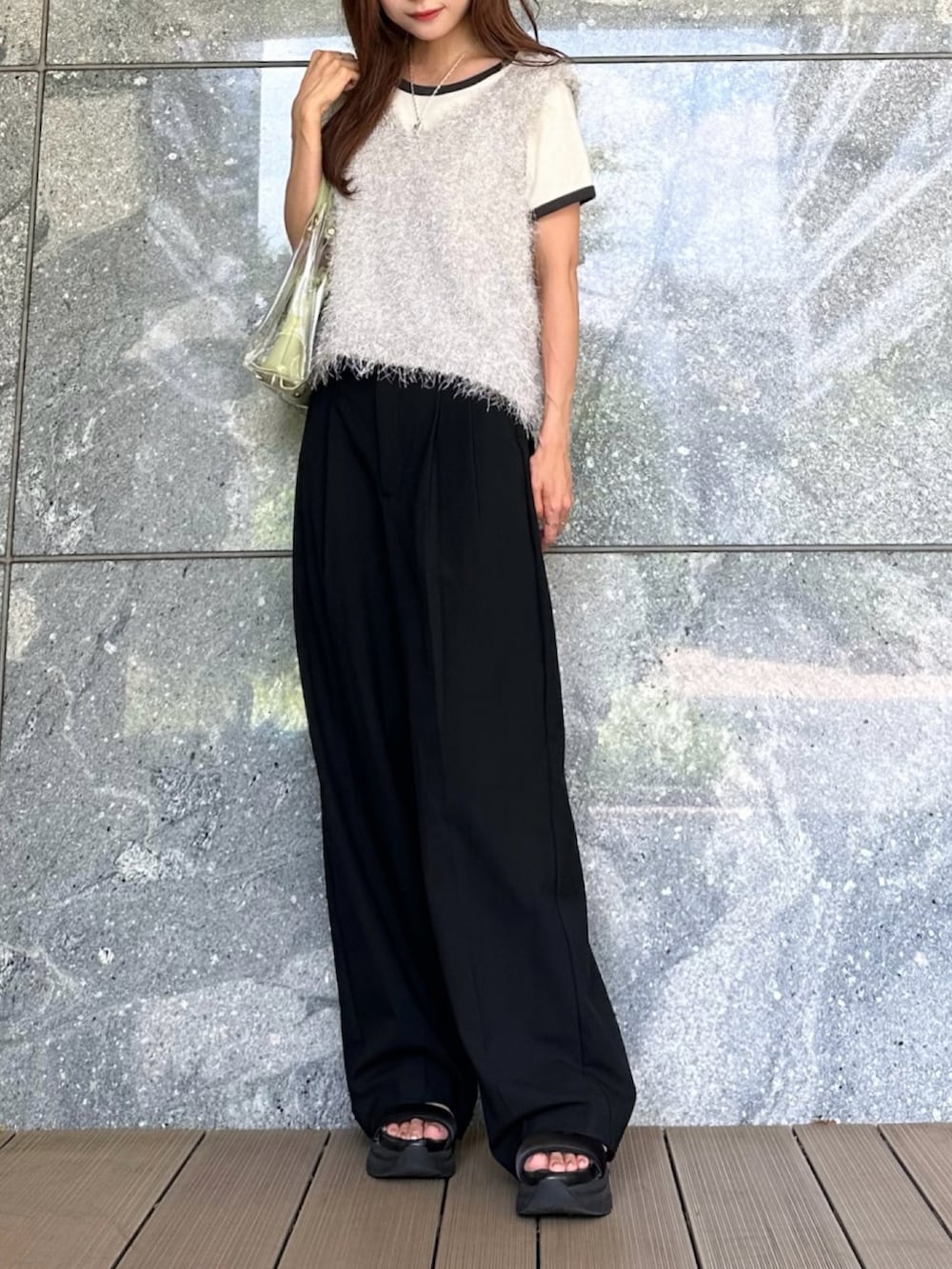 グレー系のベスト、グリーン系のショルダーバッグ、ブラック系のサンダルを着用したレディースの夏コーディネートの2枚目の写真