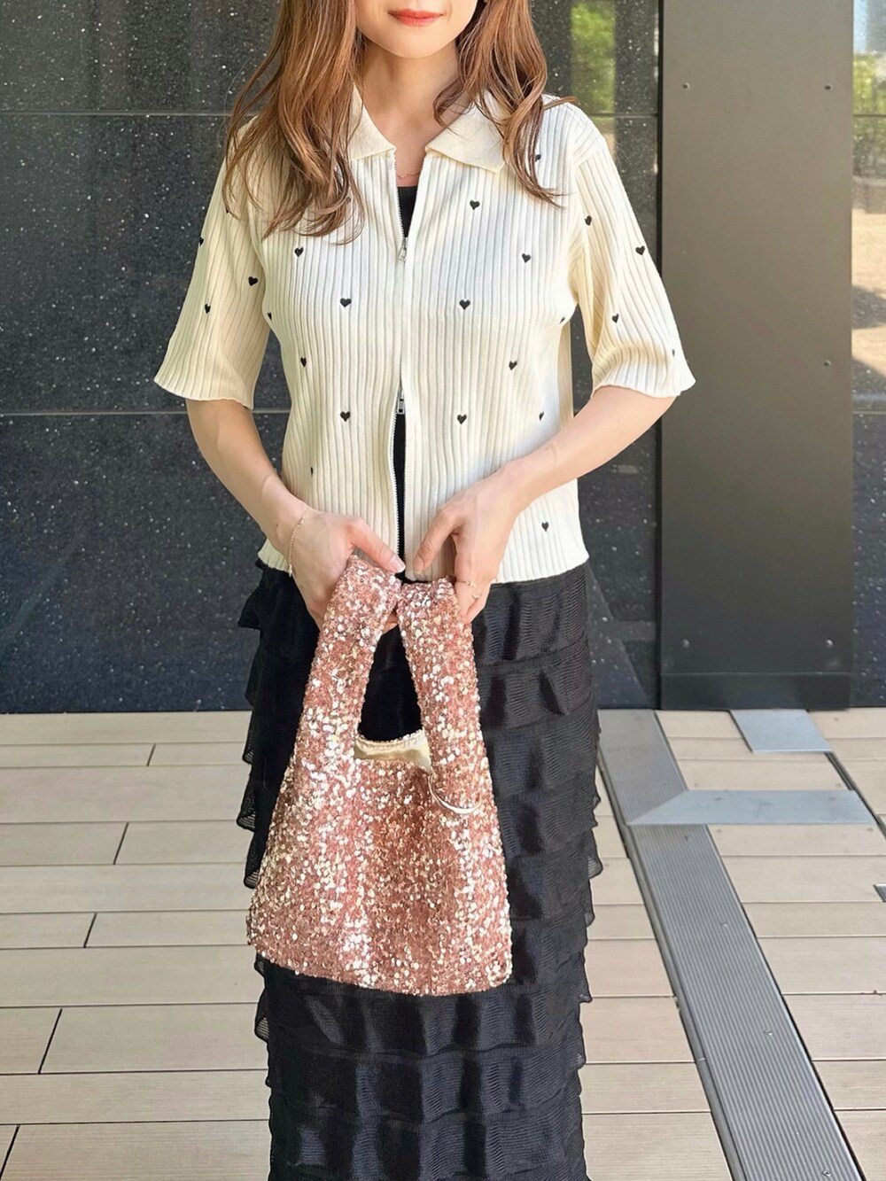 ホワイト系のニット/セーター、ブラック系のスカート、ピンク系のハンドバッグを着用したレディースの春コーディネートの3枚目の写真