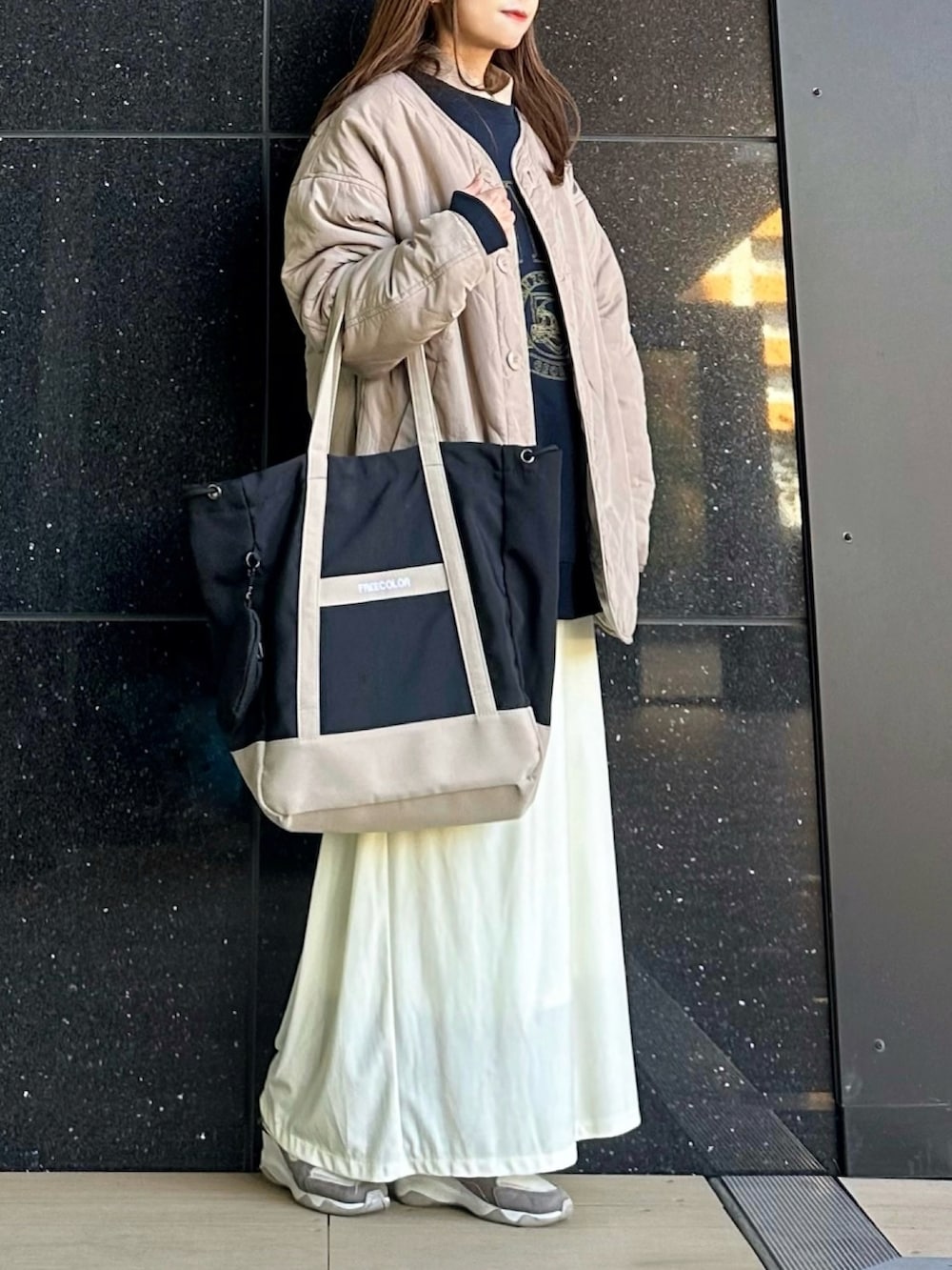 ブラック系のトートバッグ、ブルー系のスウェット、ベージュ系のシャツ/ブラウスを着用したレディースの冬コーディネートの2枚目の写真