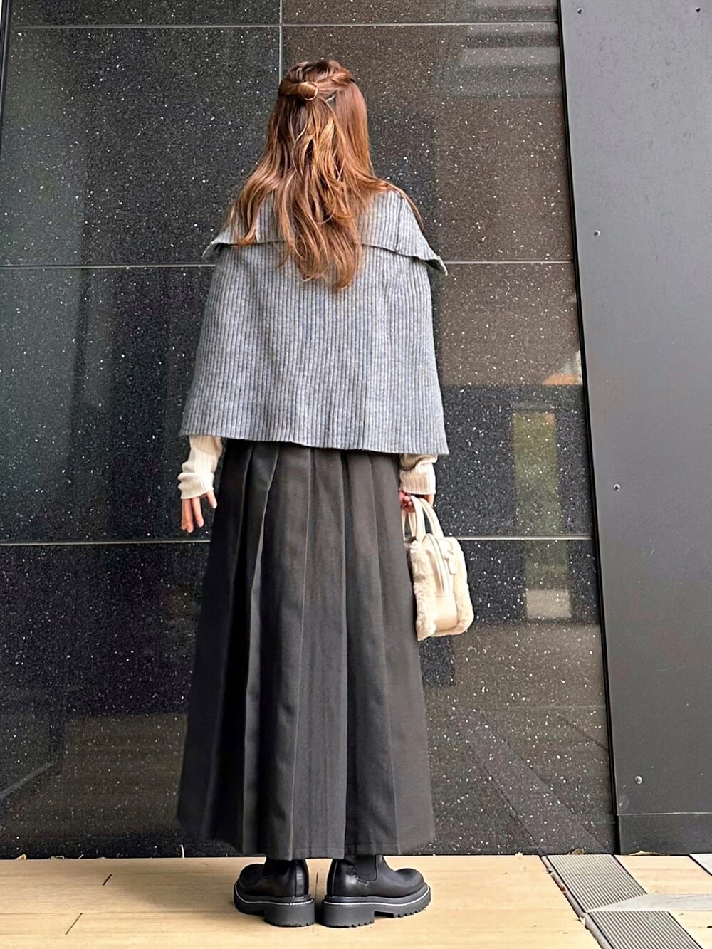 ベージュ系のニット/セーター、ブラック系のブーツ、ブラック系のスカートを着用したレディースの秋コーディネートの2枚目の写真