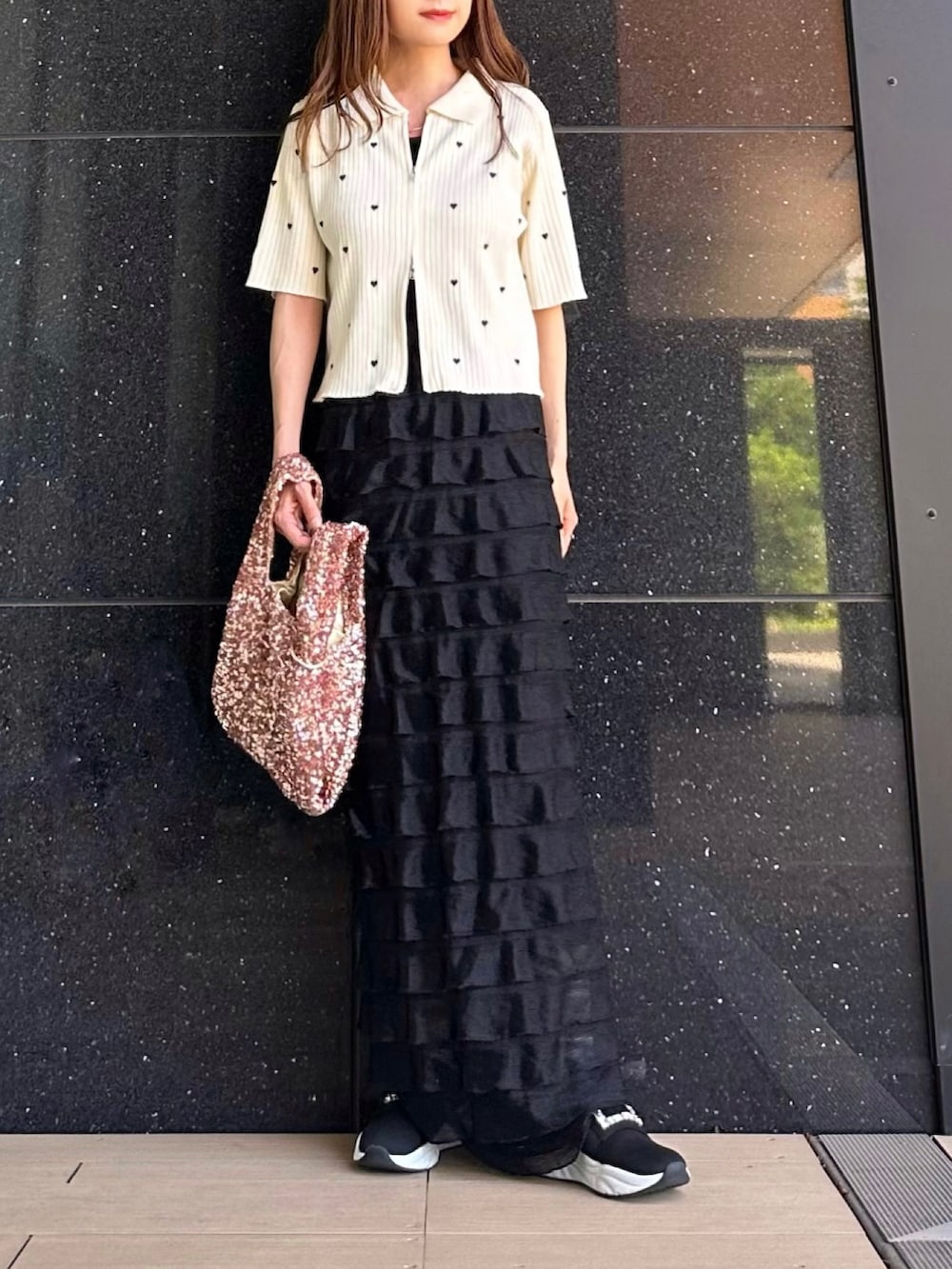 ホワイト系のニット/セーター、ブラック系のスカート、ピンク系のハンドバッグを着用したレディースの春コーディネートの2枚目の写真