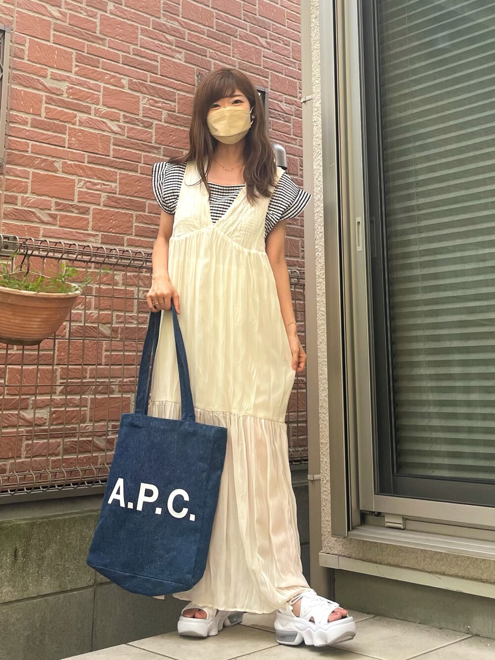 ホワイト系のサンダル、ブラック系のTシャツ/カットソー、ホワイト系のワンピースを着用したレディースの夏コーディネートの2枚目の写真