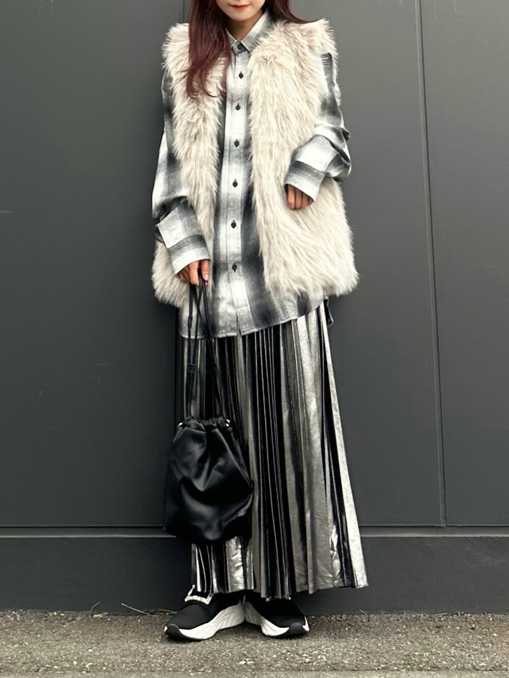 ベージュ系のベスト、ブラック系のスリッポン、ホワイト系のシャツ/ブラウスを着用したレディースの秋コーディネートの2枚目の写真