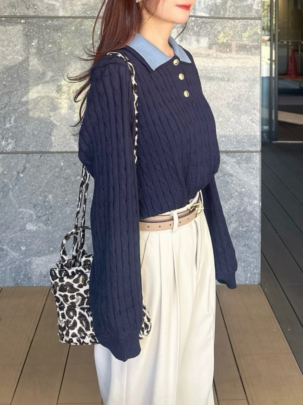 ブルー系のニット/セーター、グレー系のローファー、ブラック系のショルダーバッグを着用したレディースの冬コーディネートの4枚目の写真