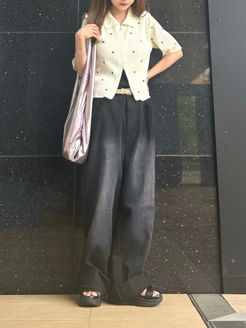 ブラック系のデニムパンツ、ホワイト系のニット/セーター、ブラック系のキャミソールを着用したレディースの夏コーディネートの2枚目の写真